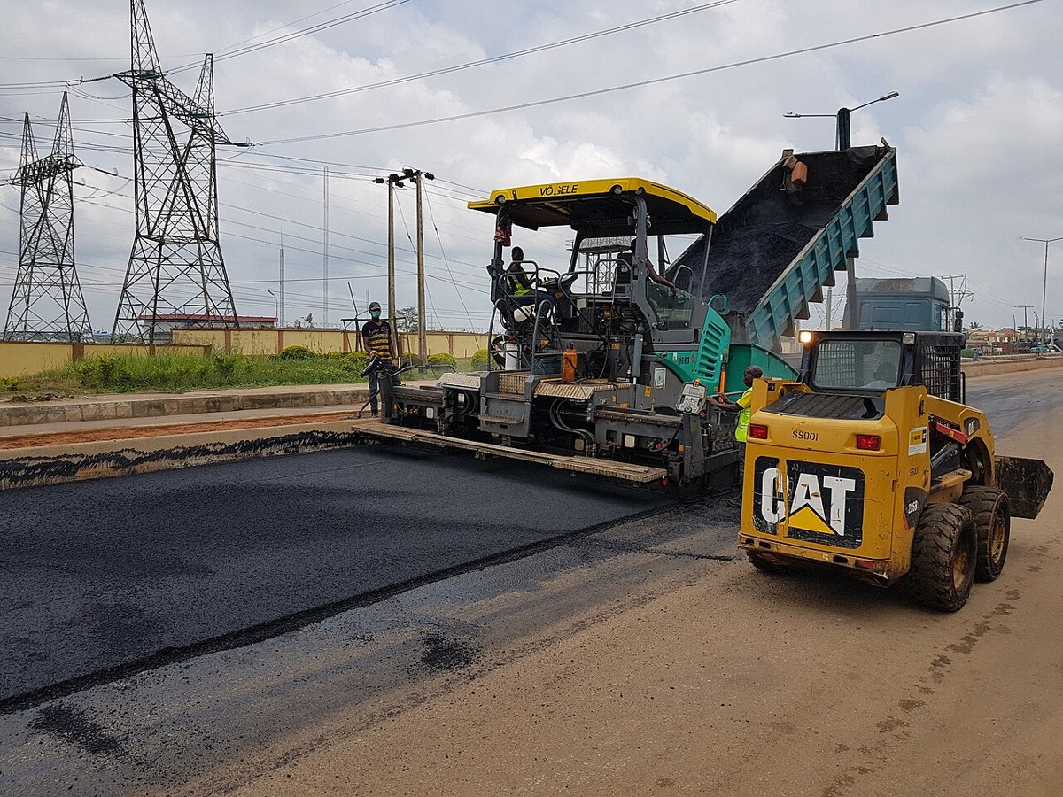 Asphalt paver laying hot bitumen on a new road surface